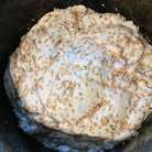 Затем нужно ещё раз интенсивно вымесить тесто, смазать форму маслом и переложить его в форму для выпекания, у меня это обыкновенный казан. Смажьте поверхность водой и посыпьте семенами льна или сезамом. Расстойка вторая под плёнкой до четкого увеличения теста в объёме в два раза около часа. 