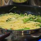 Выложить в сковороду с овощами готовые спагетти, влить 2‒3 половника воды, в которой они варились, затем добавить шпинат, перемешать и дать ему поплыть.