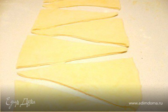 Раскатать тесто в прямоугольник толщиной ½ см. Ножом для пиццы или простым острым ножом порезать на треугольники, высотой около 18-20 см.