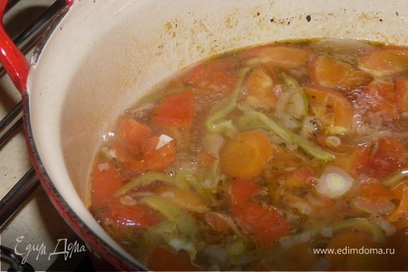 В большой кастрюле на оливковом стушить лук +чеснок. Добавить морковь (кружками) + травы, затем бульон и помидоры (нарезаные мелко, лучше без кожи). Варить минут 30.