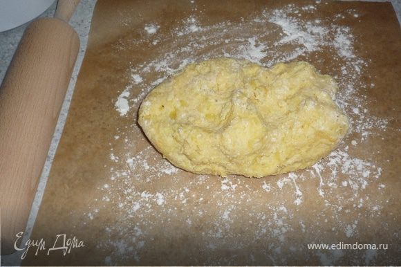 К картошке добавить 2 яйчных желтка, муку и мускатноый орех. Тщательно перемешать. Картофельное тесто выложить на посыпанную мукой бумагу для запекания или пленку.