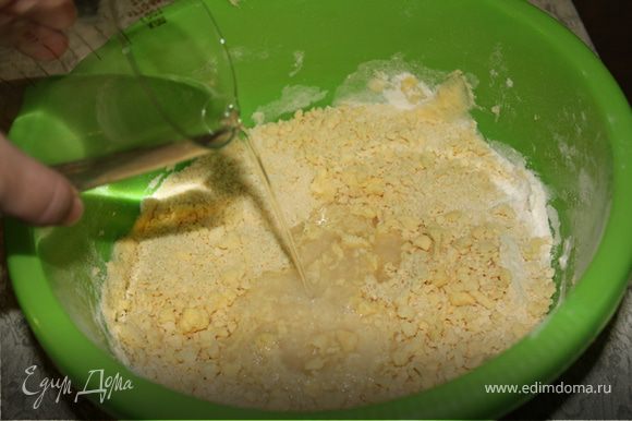 В воде развести соль и уксус, постепенно вылить в масляную крошку и замесить тесто.