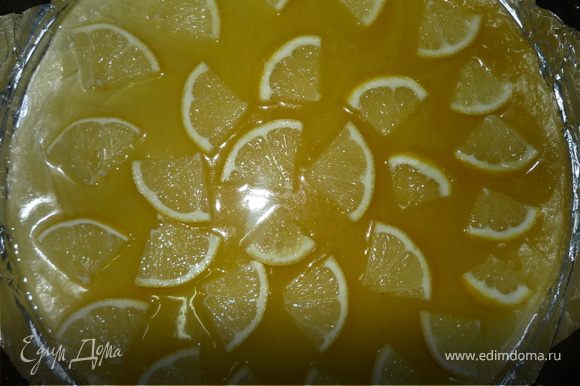 Форму для выпечки 28 см смазать рафинированным растительным маслом, выстелить фольгой (бумагой для выпечки), вылить половину карамели и выложить резаный лимон.