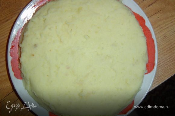 Выложить на тарелку порцию картофельного пюре и разровнять его ложкой.