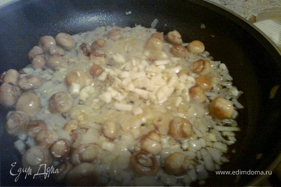 Когда лук и грибы почти готовы, добавляем мелко нарезанный чеснок и отставляем сковороду с огня.