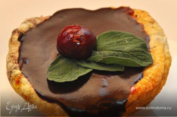 Сверку заливаем наши пирожные шоколадом, даем им немного постоять, пока шоколад не застынет, а затем украшаем листочками мяты и ягодкой вишни.