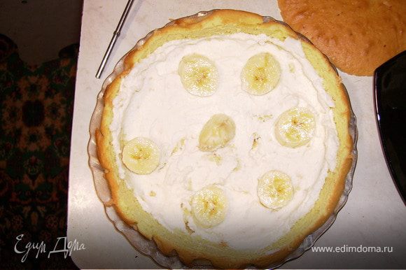 Мякоть бисквита поломать на крошки и смешать с 2/3 части всего крема. Выкладываем слой крема и на него порезанный банан.