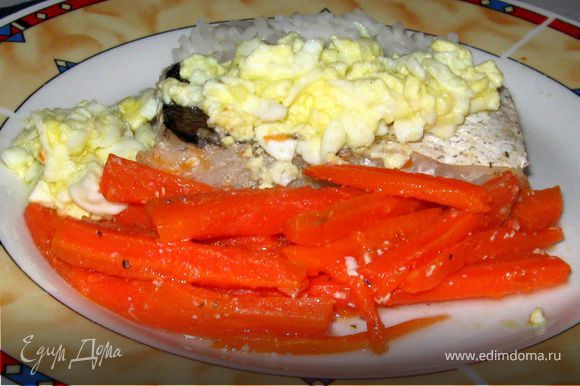 Выложить на рыбу соус, посыпать зеленью укропа. На гарнир можно подать отварной рис. А можно приготовить больше моркови. Она получается очень вкусной. Или отварить броколли.