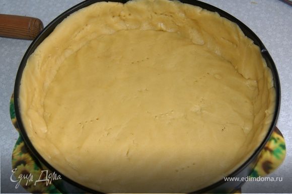 Смазать разъемную форму маслом, лучше сливочным или маргарином, и простелить бумагой для выпечки. Раскатать тесто толщиной 0,5 см. Распределить тесто по форме, вилкой сделать дырочки, чтобы тесто дышало.