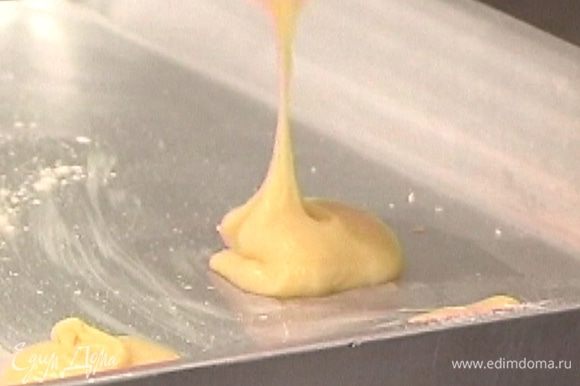 Смазать противень оставшимся сливочным маслом и ложкой выложить тесто в форме шариков на расстоянии 2−3 см друг от друга (можно использовать кондитерский шприц и выдавить «правильные» длинные эклеры).