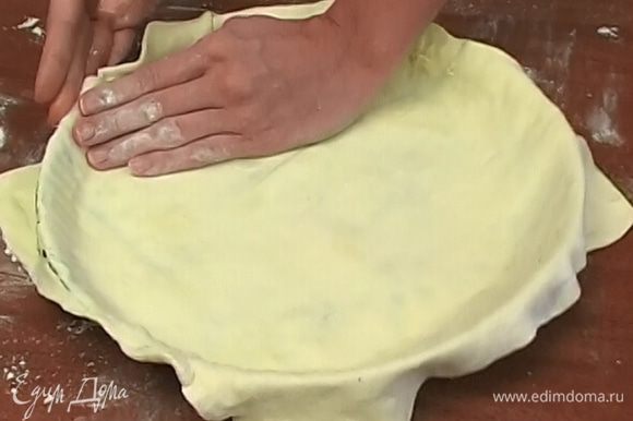 Слоеное тесто раскатать, уложить в форму, так чтобы свисали края, и смазать оливковым маслом.