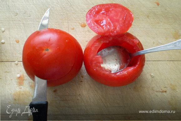 Отрезать но не до конца нижнюю часть помидора,потому что она мягче верхней( чтобы во время варки не лопнула и не рассыпалась).Мякоть помидора вырезать в начале ножом,а потом вычистить чайной ложкой.Мякоть не выбрасывать оставить для соуса.