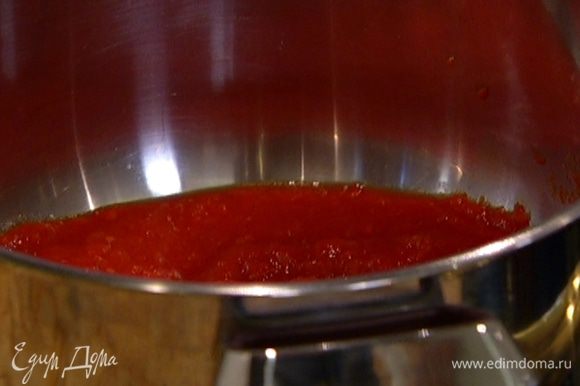 В большой кастрюле разогреть оливковое масло, обжарить нарезанный лук и 2 зубчика чеснока, добавить помидоры. Потушить 3—4 минуты и влить 3 половника бульона.