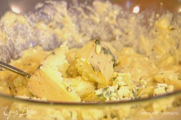 Влить растопленное масло с водой, добавить творог, яйцо, измельченный сыр и вымешать.