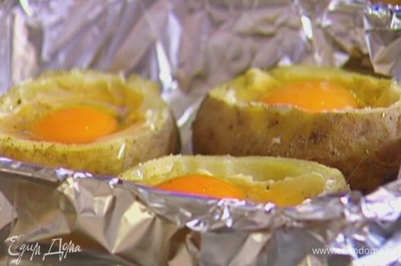 В углубления в картофеле разбить по 1 яйцу и поставить противень в разогретую духовку на 5 минут.
