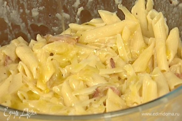 Выложить готовые макароны в блюдо с соусом, добавить оливковое масло, посыпать оставшимся сыром.