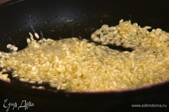 Растопить в сковороде сливочное масло, всыпать рис и дать ему пропитаться маслом.