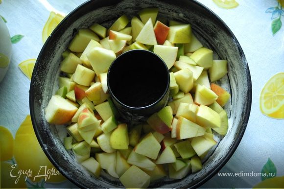 Форму смазать маслом, посыпать мукой и положить в нее нарезанные яблоки.