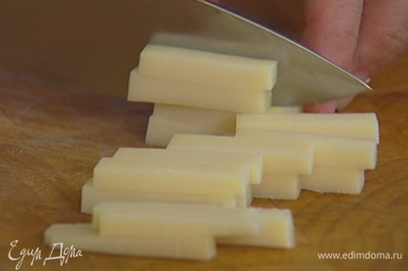 Сыр нарезать кусочками, выложить на салатные листья.