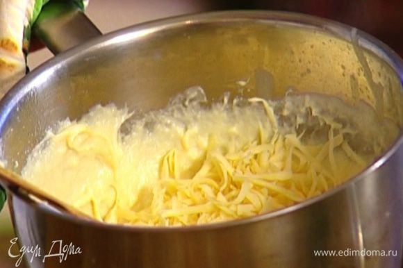 Снять кастрюлю со сливочной массой с огня, продолжая мешать, ввести желтки, затем порциями добавить сыр.