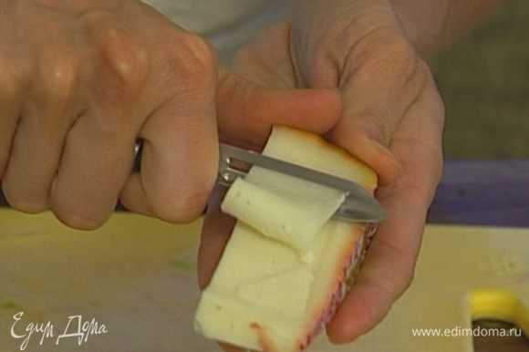 Сыр тонко нарезать с помощью ножа для чистки овощей.