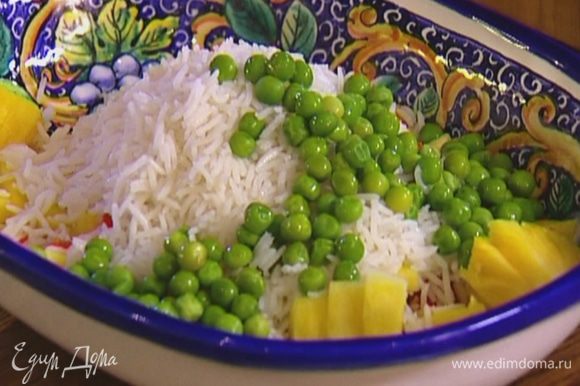 Добавить в салат вареный рис, зеленый горошек и кусочки курицы.
