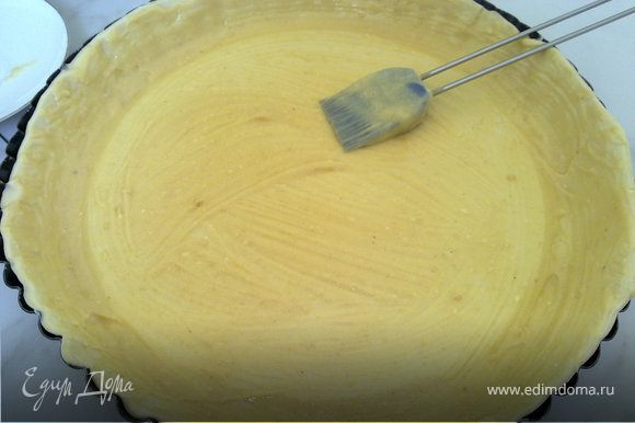 Смазываем форму для запекания маслом и выкладываем слоеное тесто. Накалываем его вилкой, и распределяем миндальный крем слоем примерно пару миллиметров.