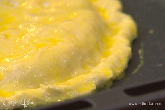 Яйцо слегка взбить и смазать лепешку. Отправить противень в разогретую духовку на 20–25 минут.