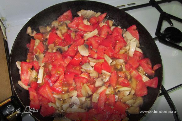 Шампиньоны и томаты порезать и выложить на предварительно разогретую с растительным маслом сковороду. Посолить, поперчить и жарить пока влага не испарится.