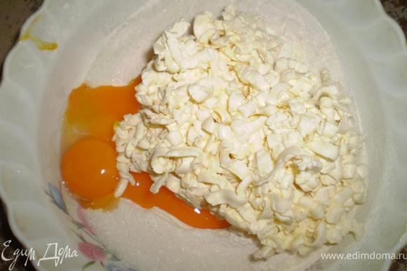 Сделаем тесто. В просеянную муку добавьте сахар, соль, желтки и натертое на терке сливочное масло.