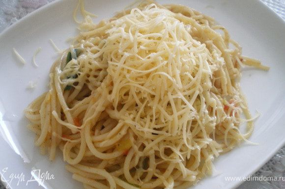Готовые спагетти украсить тёртым сыром.