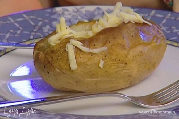 Сделать на каждой картофелине разрез вдоль до половины, вынуть немного мякоти, посолить и начинить сливочным маслом и натертым сыром.