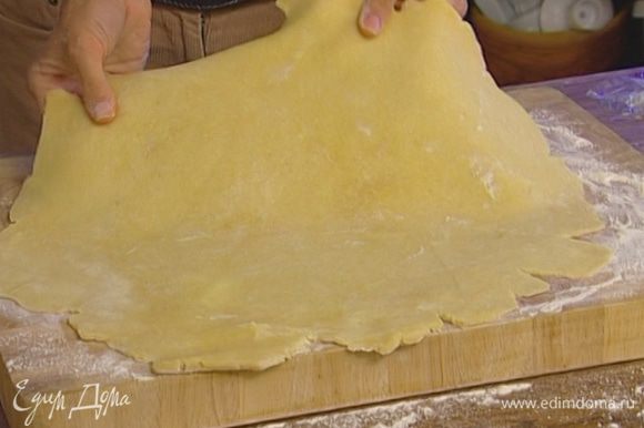 Охлажденное тесто сначала размять руками, а потом раскатать в большой пласт толщиной 3 мм. Края могут получиться неровными, это будет выглядеть даже более аппетитно.