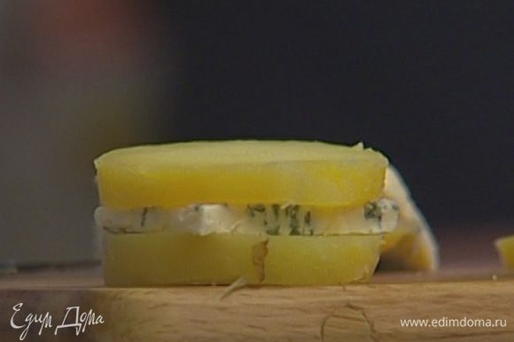 На каждый кружок картофеля положить кусочек сыра, сверху накрыть вторым кружком картофеля.