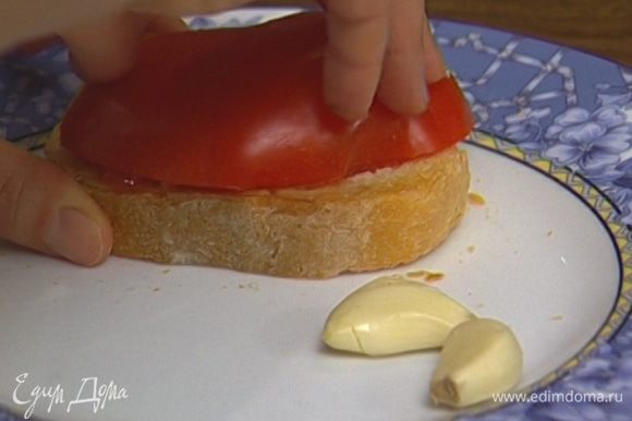 Натереть каждый тост чесноком, а затем половинкой помидора (в результате в руках должна остаться только кожица).
