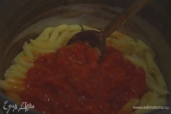 Перемешать макароны с томатным соусом.