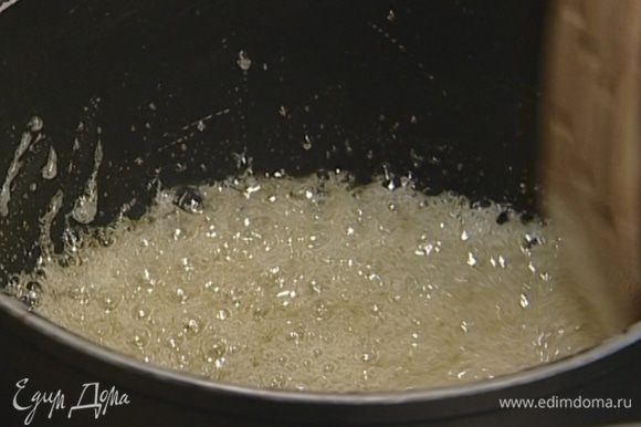 Сахар всыпать в маленькую кастрюлю, влить 40 мл воды и сварить карамельный сироп.