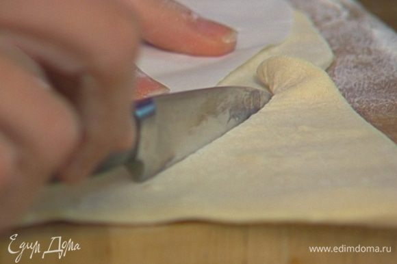 Сделать из бумаги шаблон в виде рыбы, положить на тесто и вырезать из теста рыбу, отступая от шаблона на 1 см.