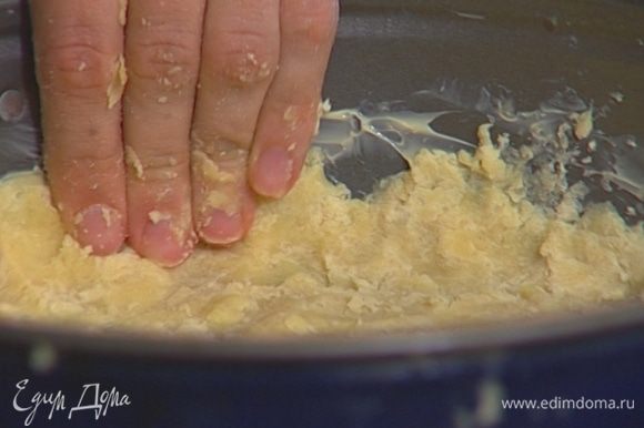 Разъемную форму смазать сливочным маслом, выложить в нее тесто, распределяя ровным слоем так, чтобы получился тонкий корж.