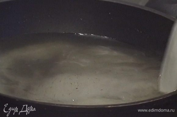 Влить в большую тяжелую сковороду 600 мл воды, всыпать ванильный сахар и поставить на огонь, чтобы сахар растворился.