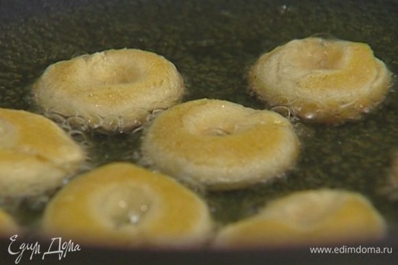 Разогреть в глубокой сковороде растительное масло и жарить пончики-бублики до золотистого цвета.