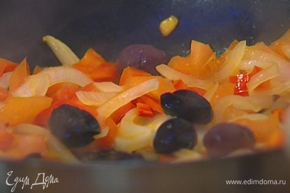 Перец, помидор, чили, оливки, две трети петрушки и чеснок добавить в сковороду к луку. Посолить и тушить на среднем огне 10 минут.