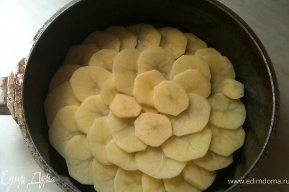 Дно формы смазать растительным маслом и выложить плотно дольки картофеля.