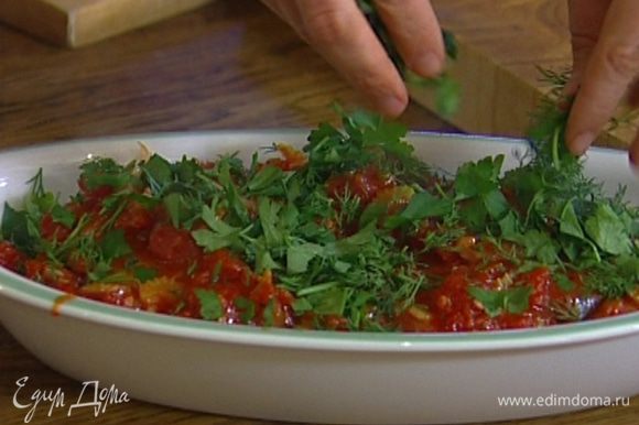 В глубокую форму, в которой можно будет подавать рыбу, уложить стейки, сверху полить томатным соусом, присыпать половиной укропа и петрушки.