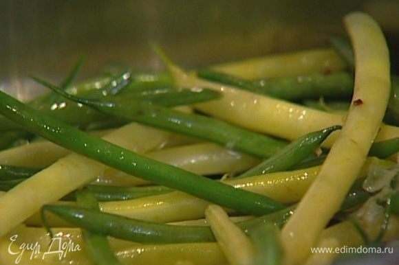 Разогреть в сковороде 2−3 ст. ложки оливкового масла, выложить в нее рубленый чеснок и фасоль, посолить, поперчить и тушить, помешивая, на медленном огне несколько минут.