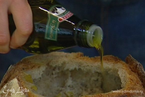 Кисточкой смазать оливковым маслом внутреннюю поверхность хлеба.