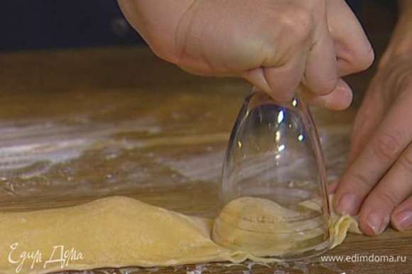 Раскатать тесто в тонкий пласт толщиной 1−2 мм, стаканом или чашкой вырезать кружки, положить в центр каждого начинку и защипнуть края.