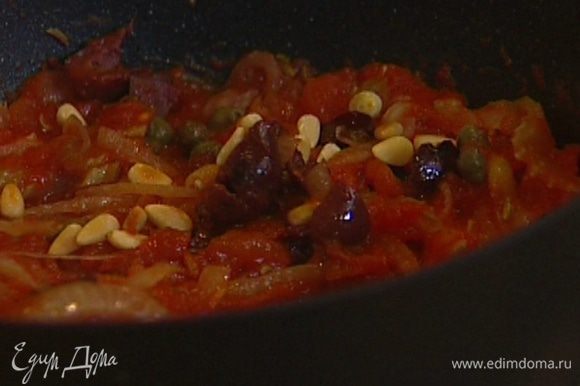 Сковороду с томатным соусом снять с огня, добавить оливки, каперсы, половину кедровых орехов, перемешать.