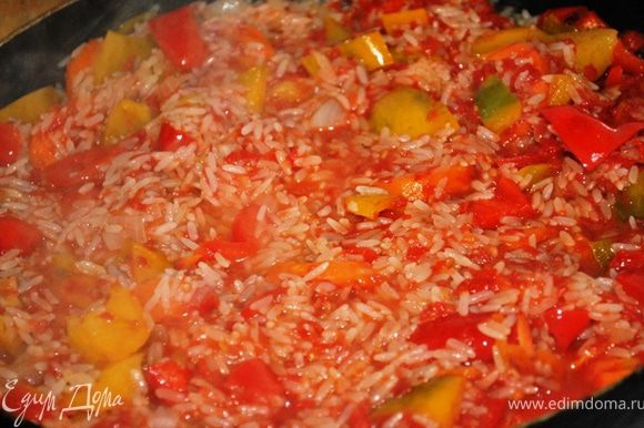 Всыпать рис, залить томатным соком и тушить до готовности риса на медленном огне.