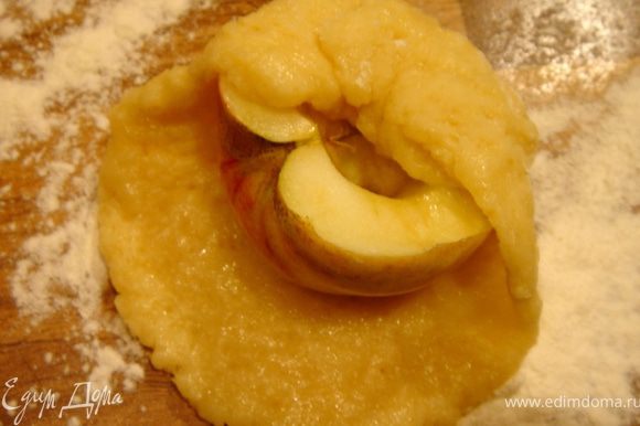 Тесто разделить на 12 частей(если фрукты крупные,то разделите тесто на своё усмотрение). Раскатайте каждую часть в лепёшку,сверху положите половинку яблока,срезом вверх.В выемку в яблоке можно разместить орех.Соберите края лепёшки вокруг яблока.